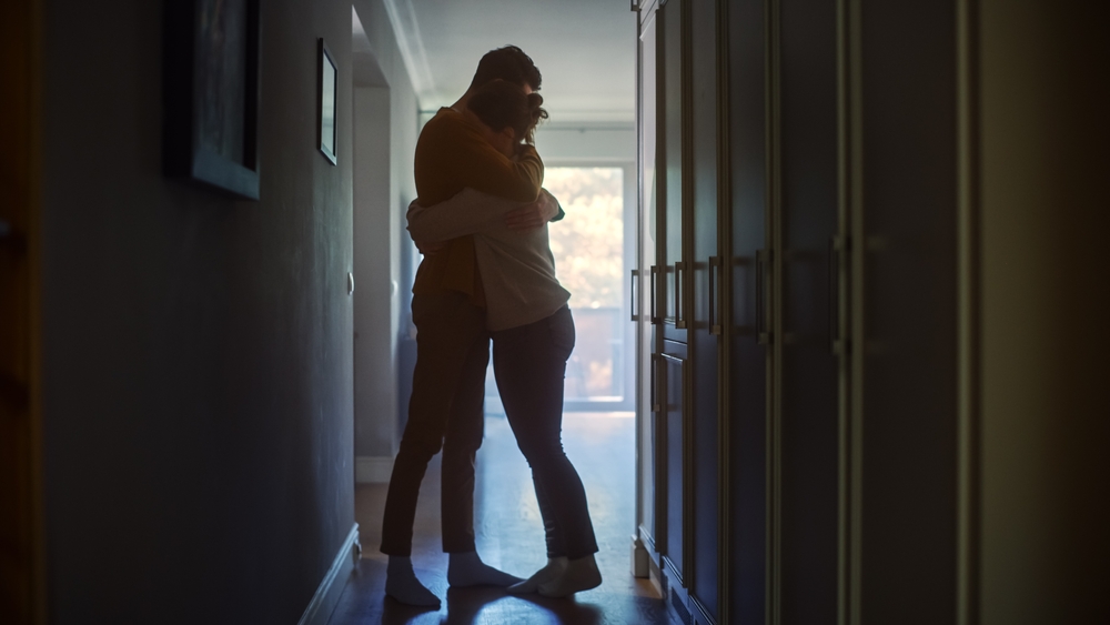 couple hugging in dark hallway